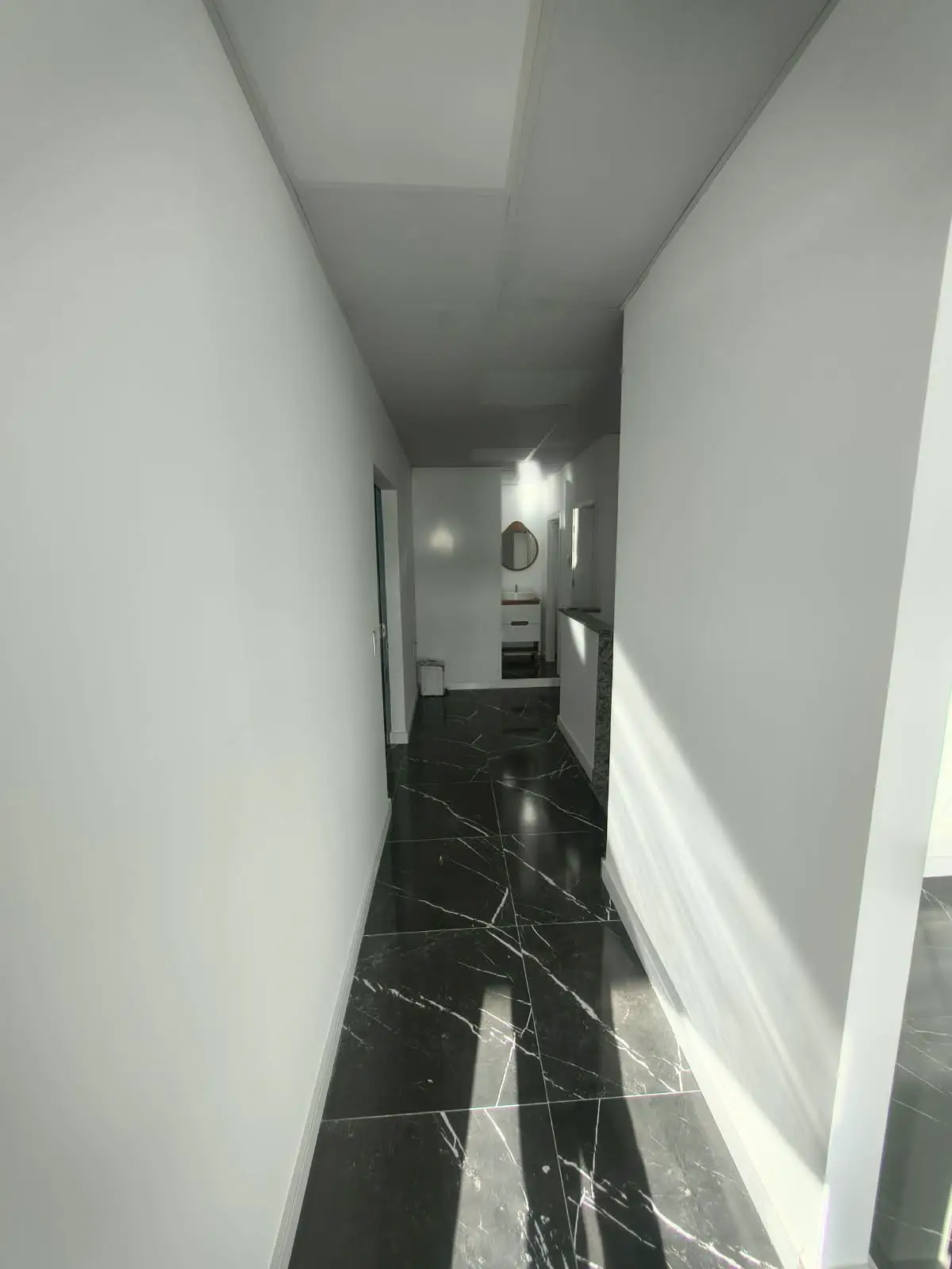Circulação em porcelanato preto com acesso ao banheiro