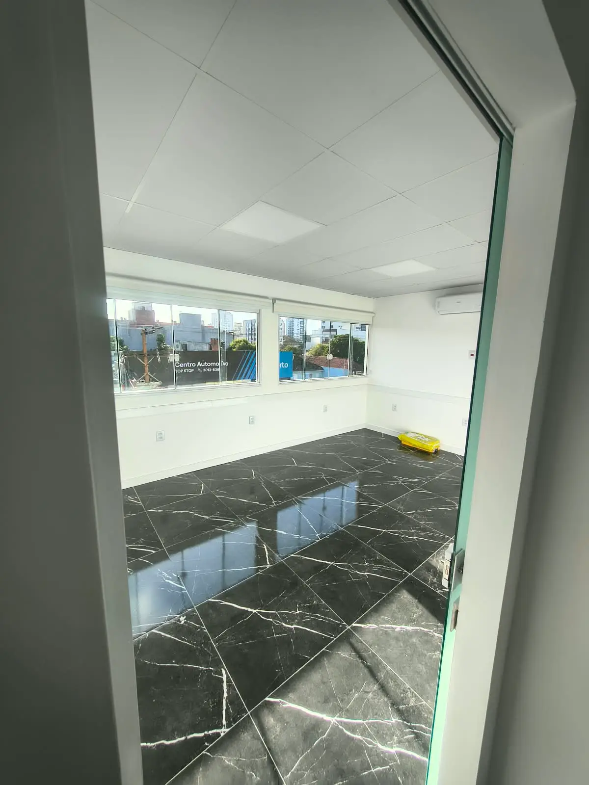 Sala com piso em porcelanato preto e vista para a cidade
