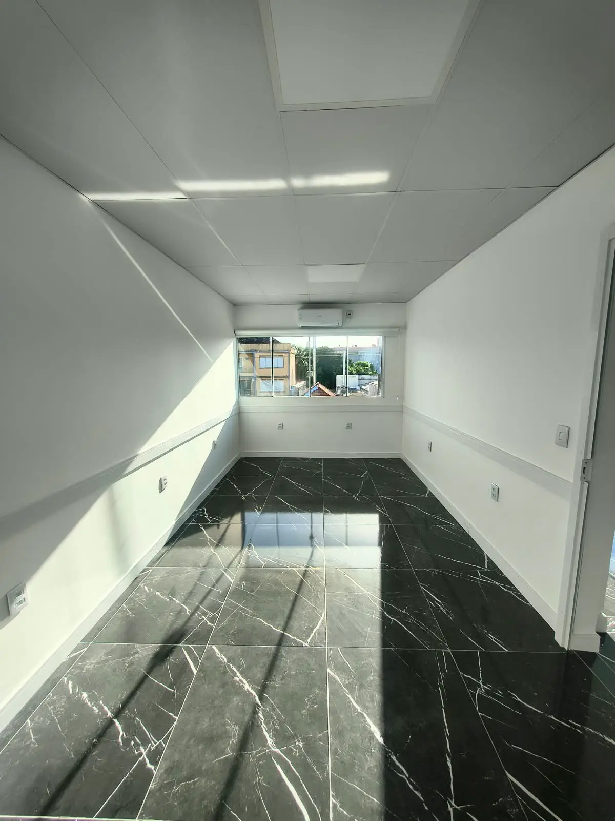 Sala com ar-condicionado instalado e vista para a cidade