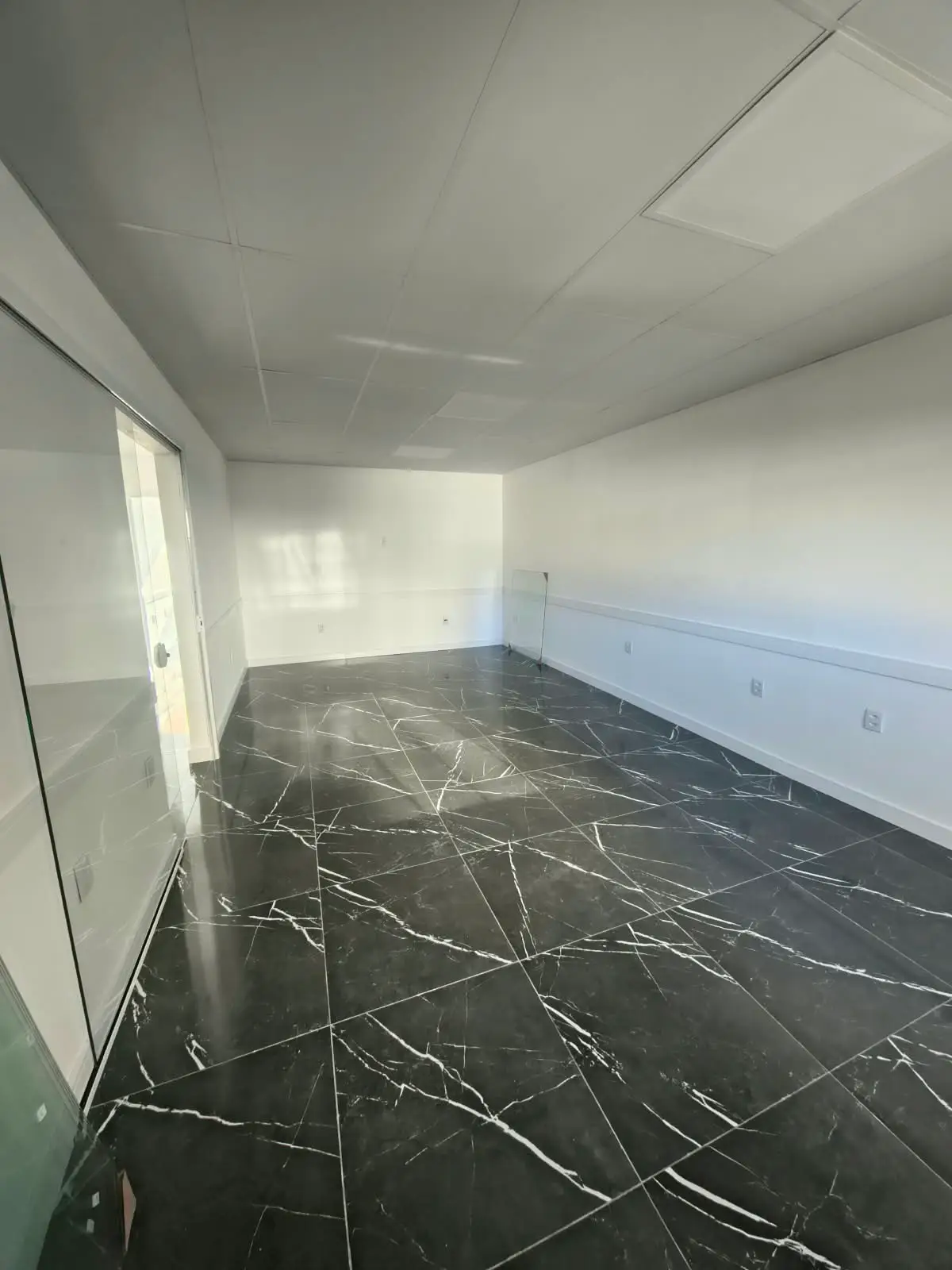 Sala com porta de vidro e piso em porcelanato preto