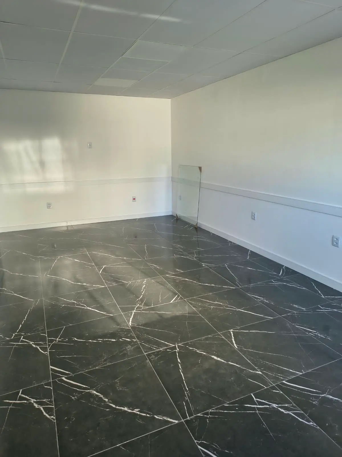 Sala com piso em porcelanato preto pronta para os acabamentos finais